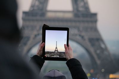 Low angle view of woman using digital tablet eiffel tower