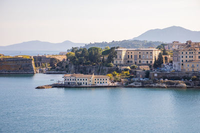 Scenic view of sea and buildings against clear sky