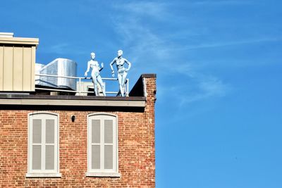 Low angle view of statue against building against sky