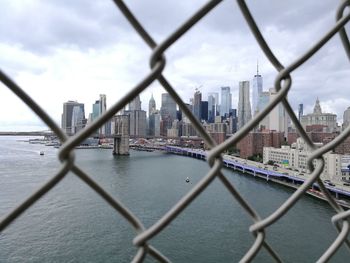 View of buildings seen through chainlink fence