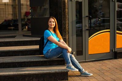 Portrait of young woman sitting on staircase