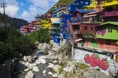 Houses by canal amidst buildings in city