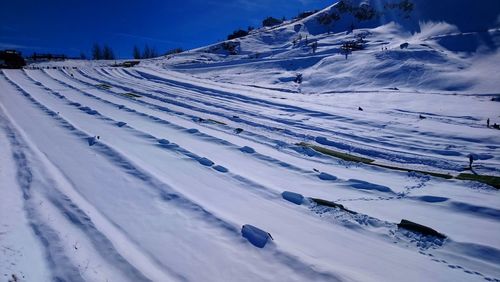 Snow covered land and mountains against sky