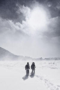 Rear view of people on snow against sky