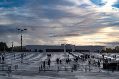 People on street against sky at sunset