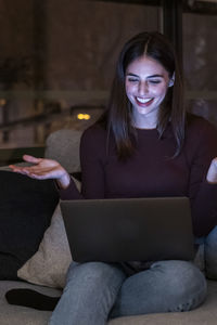 Portrait of young woman using laptop at home