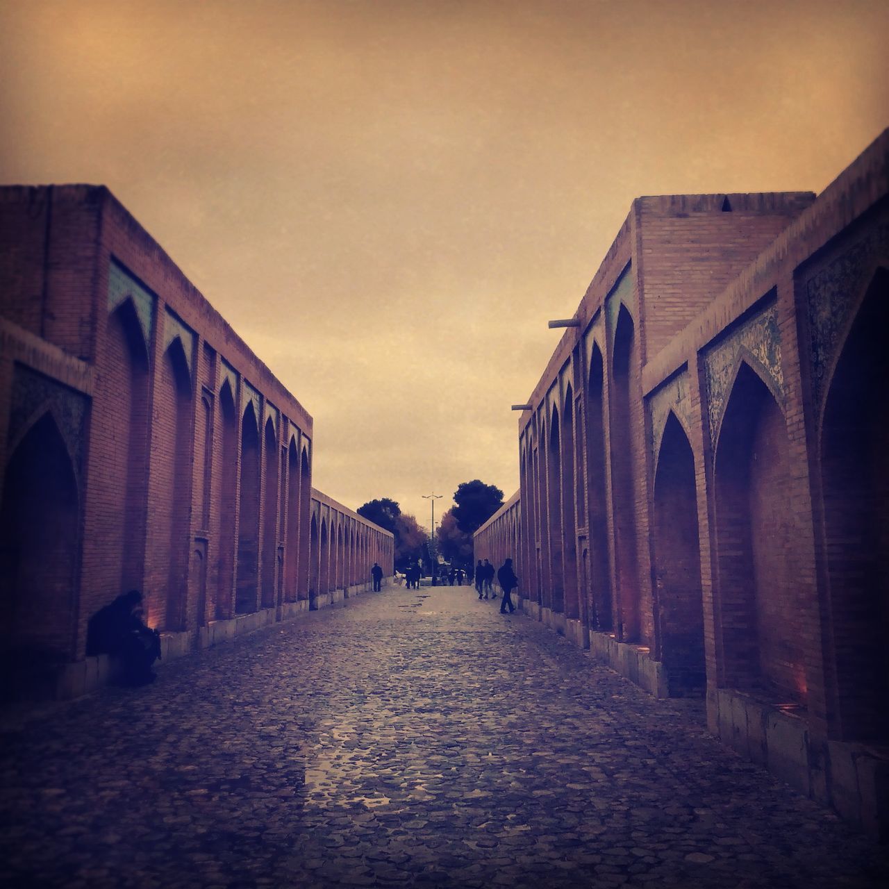 architecture, built structure, building exterior, the way forward, sky, diminishing perspective, arch, vanishing point, street, building, cobblestone, cloud - sky, city, incidental people, history, outdoors, walkway, in a row, cloud, travel destinations