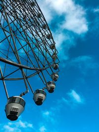 Low angle view of ferris wheel against blue sky