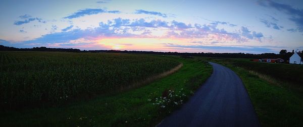 Scenic view of agricultural field against sky at sunset