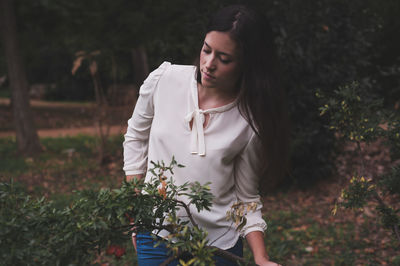 Portrait of woman standing by plants