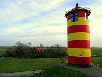 Lighthouse against cloudy sky