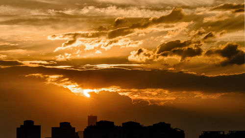 Silhouette buildings against sky during sunset