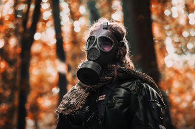 Man photographing through camera in forest during winter