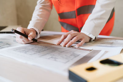 Unrecognizable architect woman in construction site working on blueprints. home improvement