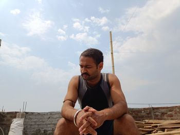 Low angle view of man sitting on beach