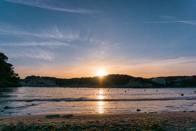 Scenic view of beach against sky during sunset