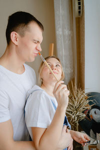 Young woman applying make-up to daughter at home