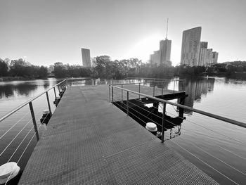 Scenic view of river by buildings against sky