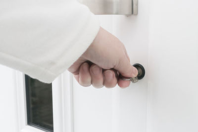 Cropped image of woman unlocking door with key