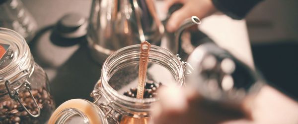 Close-up of spoon in coffee beans on container