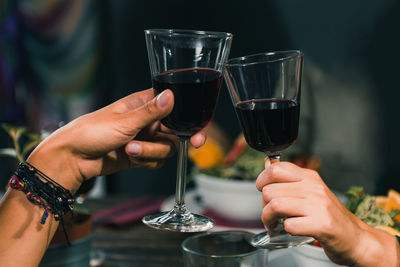 Cropped hands toasting wineglasses at restaurant