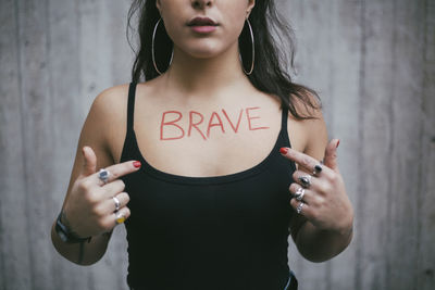 Midsection of woman standing against wall