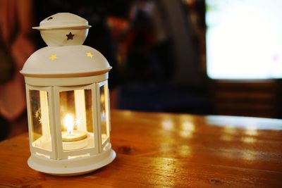 Close-up of illuminated lamp on table at home