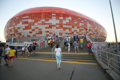 Group of people walking on road along buildings