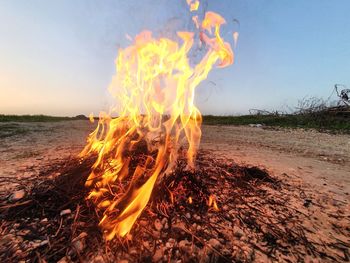 Panoramic view of bonfire on field against sky