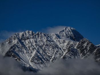 Scenic view of snowcapped mountains against blue sky