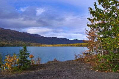 Scenic view of lake by mountains against sky