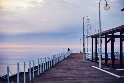 Pier on sea against sky during sunset