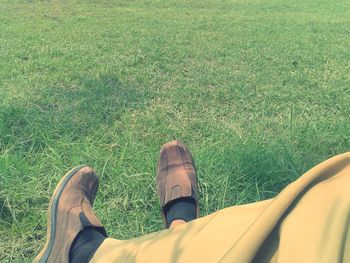 Low section of man sitting on grassy field