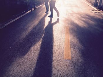 Low section of men walking on road