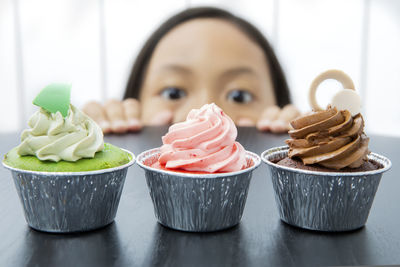 Close-up of girl looking at dessert on table