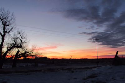 Snow covered field at sunset