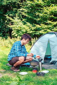 Boy preparing food on field