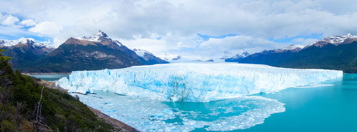 Panoramic view of sea and snowcapped mountains against sky