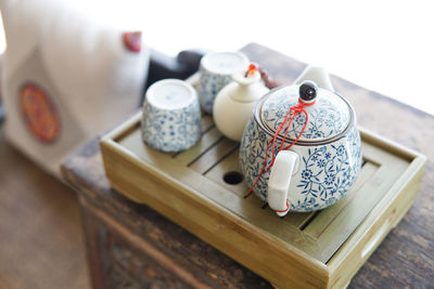 High angle view of teapot by tea cups on table at home