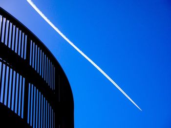 Low angle view of vapor trail against clear blue sky