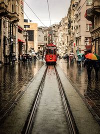 Wet street amidst buildings in city during rainy season