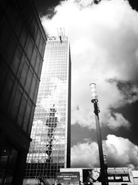 Low angle view of modern building against cloudy sky