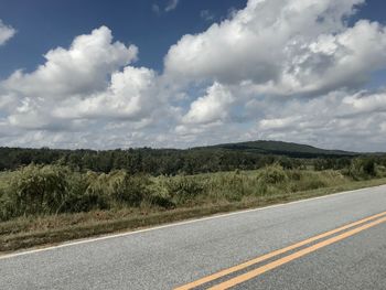 Road by landscape against sky