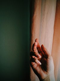 Close-up of hand against wall