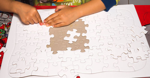 Low section of person holding paper on table