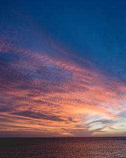 Scenic view of sea against dramatic sky during sunset