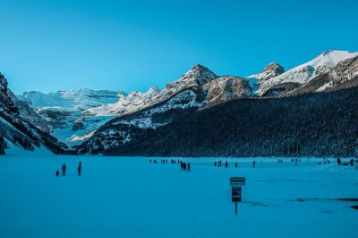 Scenic view of snowcapped mountains against clear blue sky