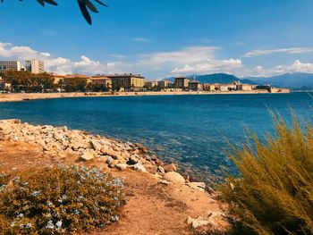 Scenic view of sea by city against sky