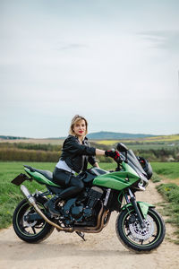 Woman in leather jacket on green motorcycle. a woman sits confidently on a green motorcycle parked
