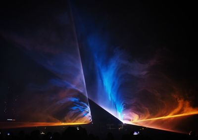 Low angle view of illuminated blue sky at night